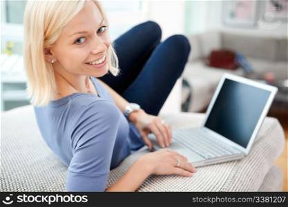 Portrait of happy blond woman using laptop