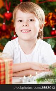 Portrait of happy boy against Christmas lights background