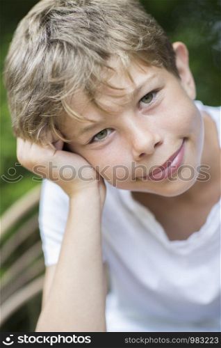 Portrait Of Happy Boy Sitting Outdoors