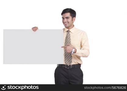 Portrait of happy businessman showing empty billboard over white background