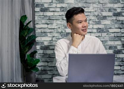 Portrait of happy businessman working at home with laptop on desk