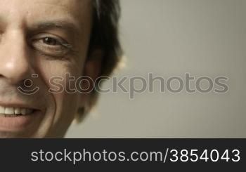 Portrait of happy caucasian adult man smiling at camera. Cropped view, grey background, copy space