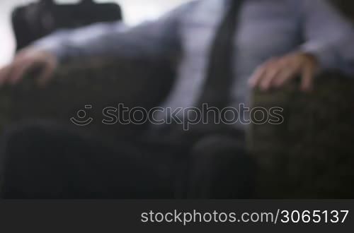 Portrait of happy caucasian businessman smiling at camera in hotel room during business trip. Rack focus
