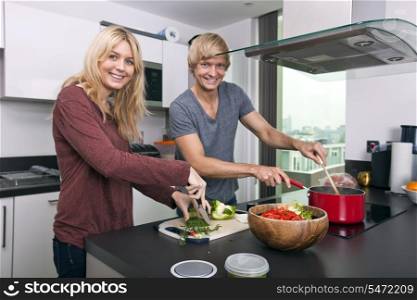 Portrait of happy Caucasian couple cooking together in kitchen