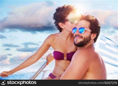 Portrait of happy cheerful cute couple kissing on sailboat, enjoying each other in romantic summer trip, spending honeymoon in the sea