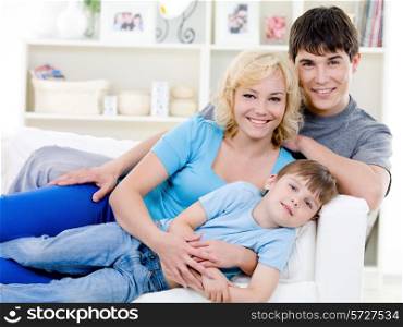 Portrait of happy cheerful family with little son with toothy smile - indoors