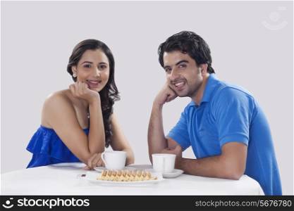 Portrait of happy couple having coffee over white background