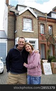 Portrait of happy couple in front of house