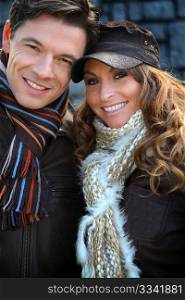 Portrait of happy couple wearing scarves in winter time