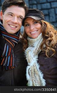 Portrait of happy couple wearing scarves in winter time