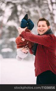 portrait of happy dad and little son having fun together in winter snowy forest. portrait of happy dad and little son having fun together in winter snowy forest.