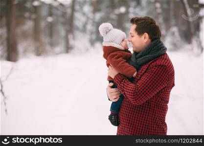 portrait of happy dad with baby son while having fun in winter forest, copy space.. portrait of happy dad with baby son while having fun in winter forest, copy space