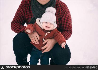 portrait of happy dad with baby son while having fun in winter forest, copy space.. portrait of happy dad with baby son while having fun in winter forest, copy space