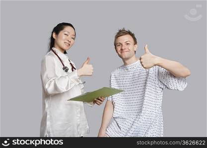 Portrait of happy doctor and patient gesturing thumbs up