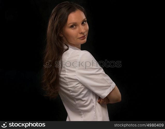 Portrait of happy doctor standing in front of black background