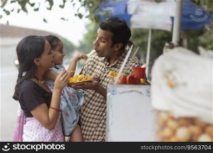 Portrait of happy family eating bhelpuri