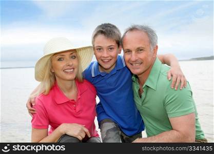 Portrait of happy family kneeling by a lake