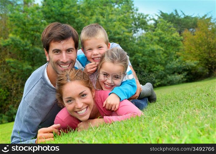 Portrait of happy family laying in country field