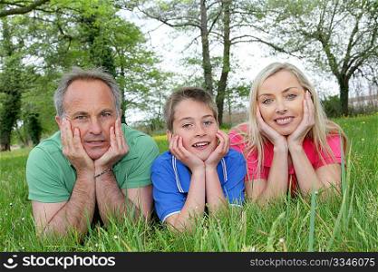 Portrait of happy family laying in grass