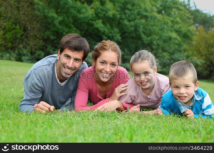 Portrait of happy family lying down in grass