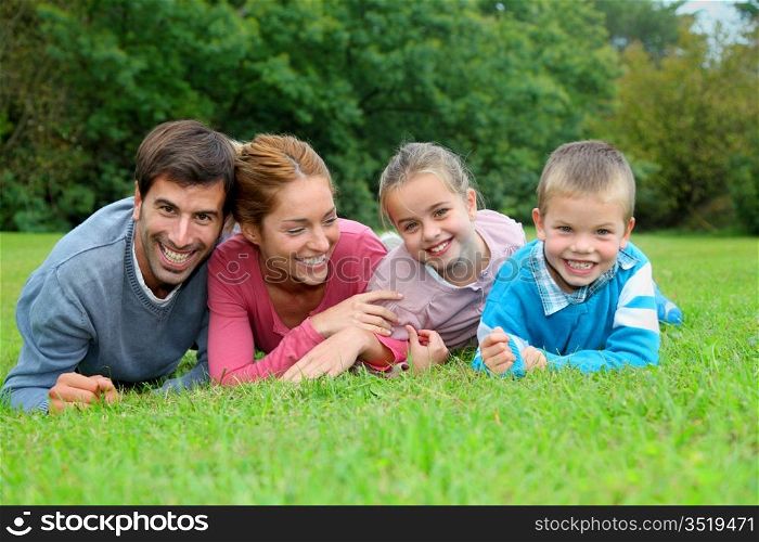 Portrait of happy family lying down in grass