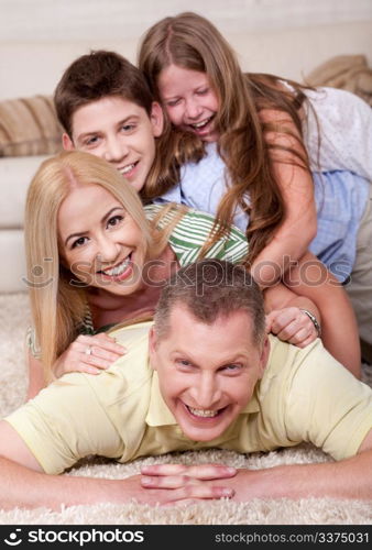 Portrait of happy family Lying On Top Of Each Other In living room