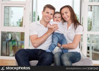 Portrait of happy family sitting on couch at home