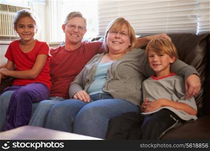 Portrait Of Happy Family Sitting On Sofa Together