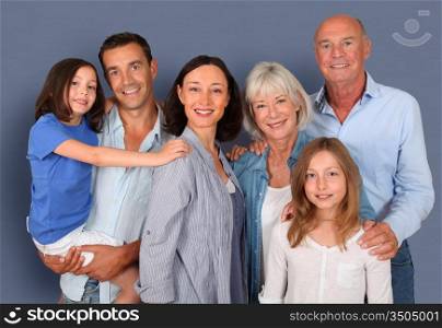 Portrait of happy family standing ion grey background