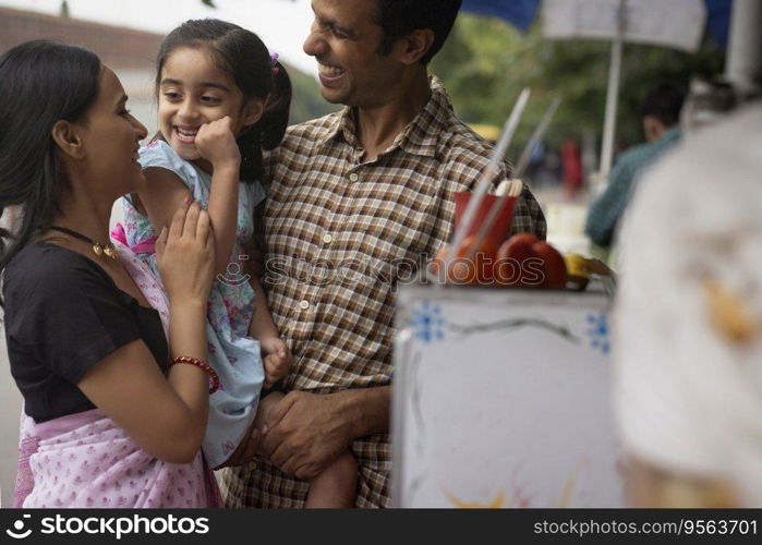 Portrait of happy family standing near street shop