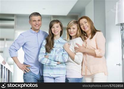 Portrait of happy family with children standing together at home