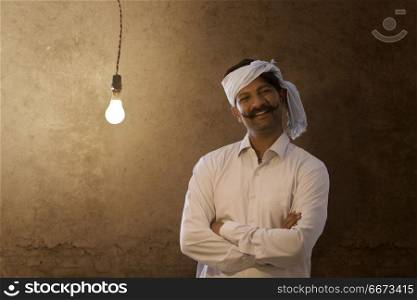 Portrait of happy farmer with light bulb in his house