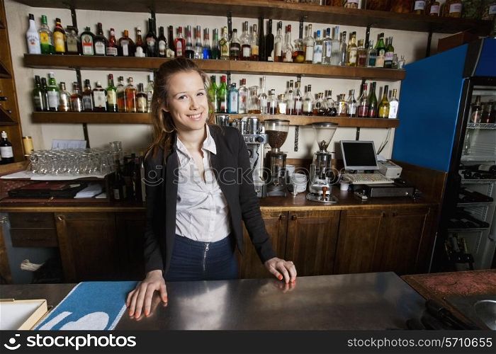 Portrait of happy female cashier at counter in restaurant