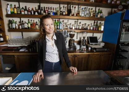 Portrait of happy female cashier at counter in restaurant