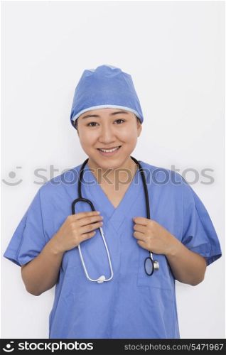 Portrait of happy female doctor with stethoscope around neck against white background