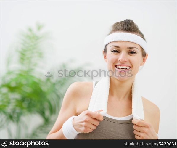 Portrait of happy fitness woman with towel on shoulders
