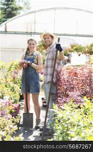 Portrait of happy gardeners standing outside greenhouse