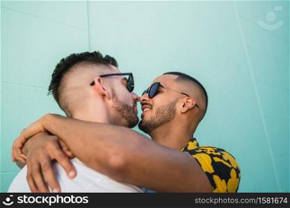 Portrait of happy gay couple hugging and kissing in the street. Lgbt and love concept.