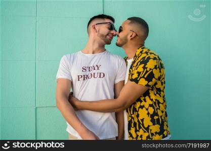 Portrait of happy gay couple hugging and kissing in the street. Lgbt and love concept.