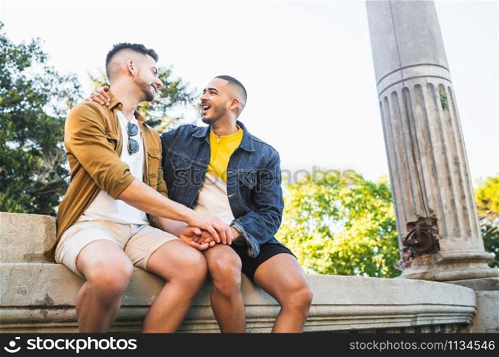 Portrait of happy gay couple spending time together and having a date at the park. Lgbt and love concept.