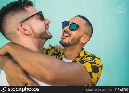 Portrait of happy gay couple spending time together and hugging in the street. Lgbt and love concept.