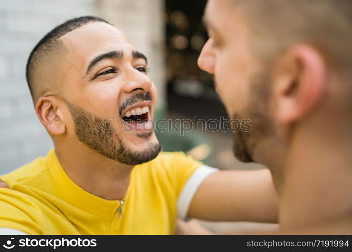 Portrait of happy gay couple spending time together and hugging in the street. Lgbt and love concept.