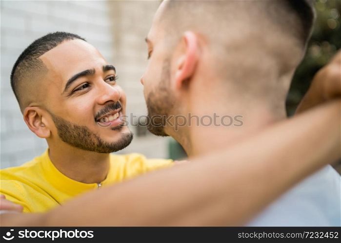 Portrait of happy gay couple spending time together and hugging in the street. Lgbt and love concept.