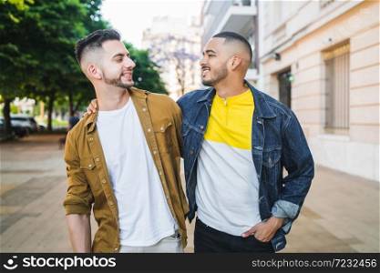 Portrait of happy gay couple spending time together while walking in the street. Lgbt and love concept.