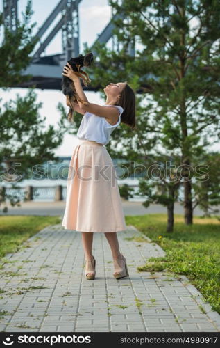 Portrait of happy girl holding her dog at city park