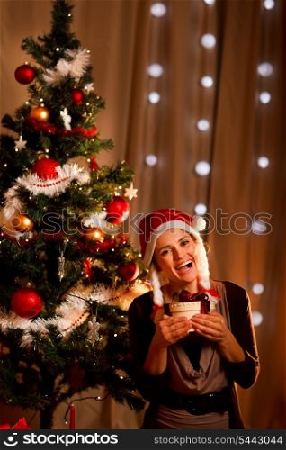 Portrait of happy girl near Christmas tree with present box&#xA;