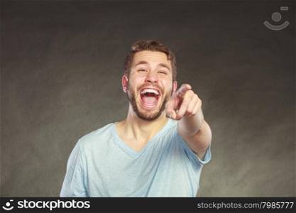 Portrait of happy handsome man in shirt laughing. Young content positive guy in studio on black.