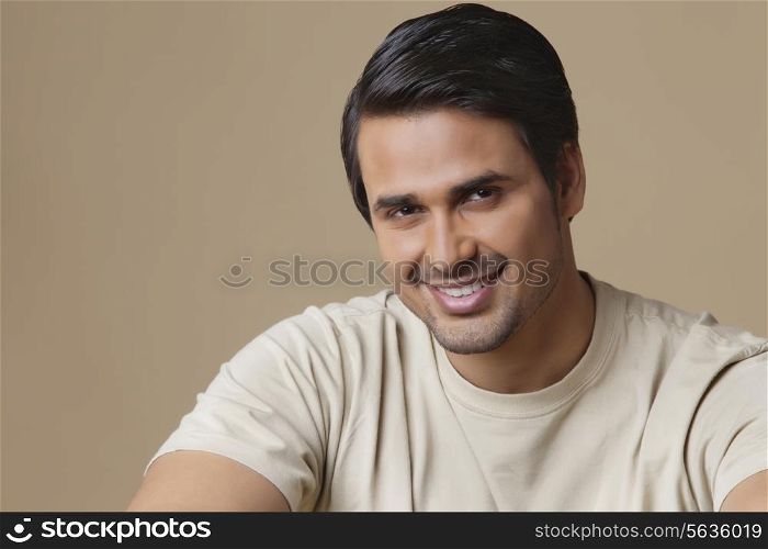 Portrait of happy Indian man over colored background