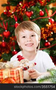 Portrait of happy kid against decorated Christmas tree