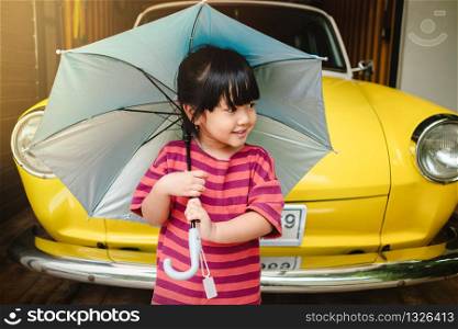 Portrait of Happy Kids with an Umbrella before Outing. Protecting Rain or Sunlight in Summer or Rainy Season Concept. Little Cute 3-4 Years Old Girl in Happiness Moment.